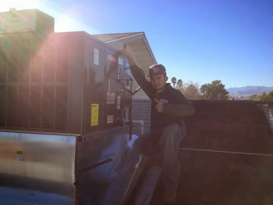 HVAC technician performing AC Tune-Up on a rooftop unit in Ocean